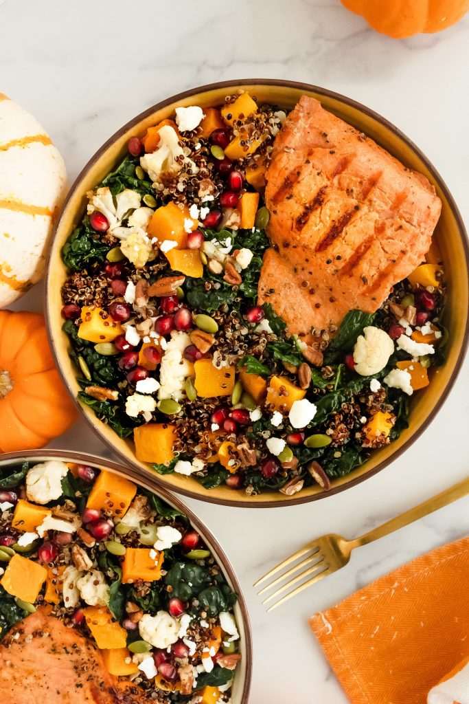 Autumn fall Salmon & Squash bowl with kale, butternut squash, apples, cauliflower, pomegranate seeds, pecans, pumpkin seeds, quinoa and feta cheese