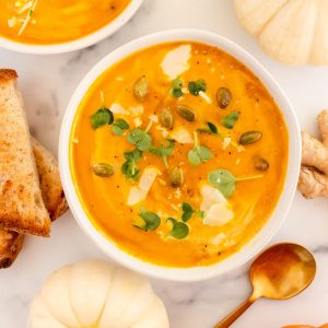 creamy dairy free pumpkin soup topped with toasted pumpkin seeds