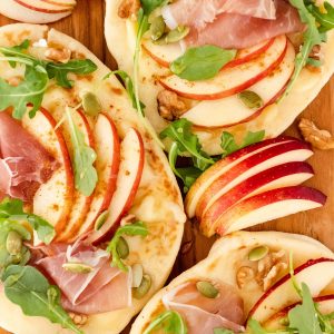 flavorful fall apple flatbread with prosciutto, apples, walnuts, brie and arugula