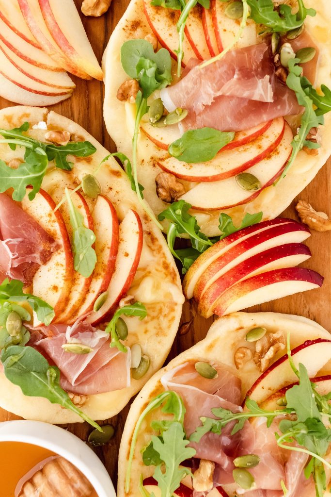 flavorful fall apple flatbread with prosciutto, apples, walnuts, brie and arugula