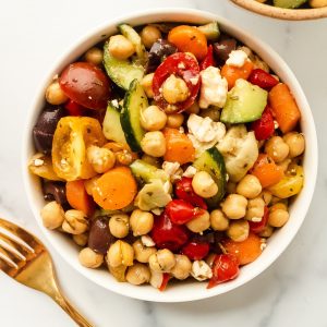mediterranean chickpea salad with cucumbers, feta, tomatoes, olives, artichokes, and carrots