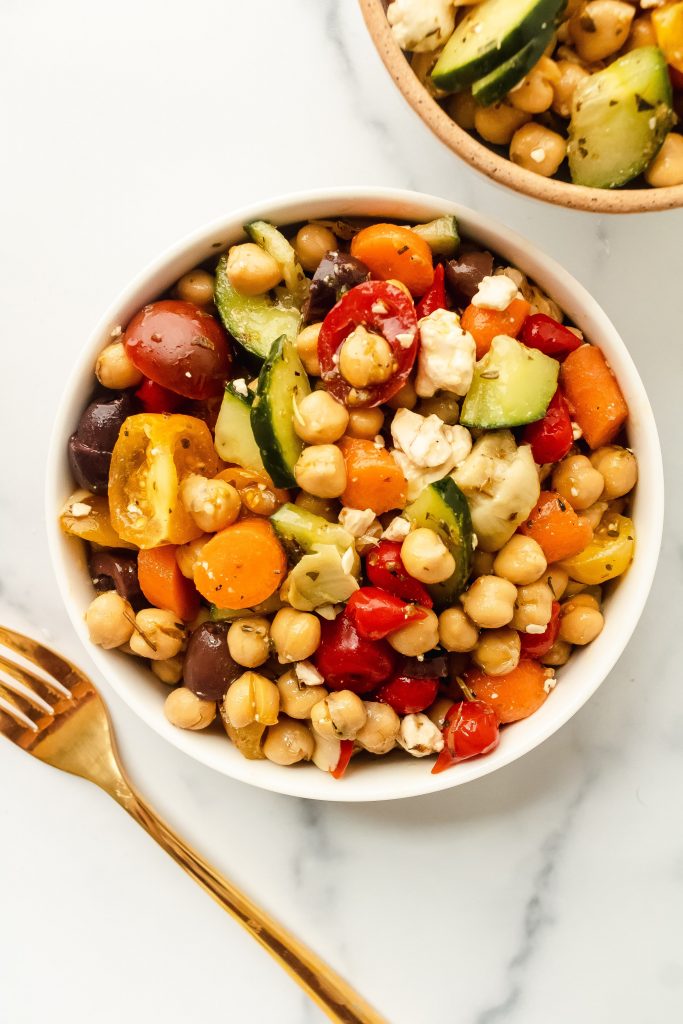 mediterranean chickpea salad with cucumbers, feta, tomatoes, olives, artichokes, and carrots