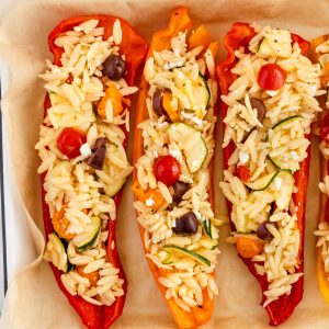 Orzo stuffed peppers with tomatoes, olives, zucchini, artichoke and feta cheese