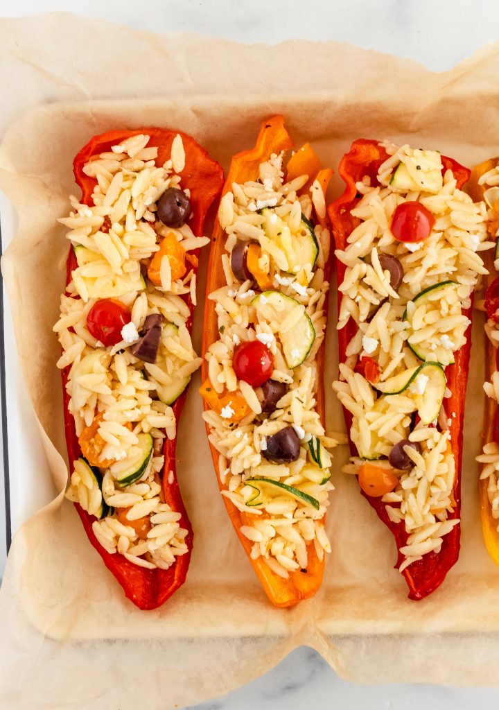 Orzo stuffed peppers with tomatoes, olives, zucchini, artichoke and feta cheese